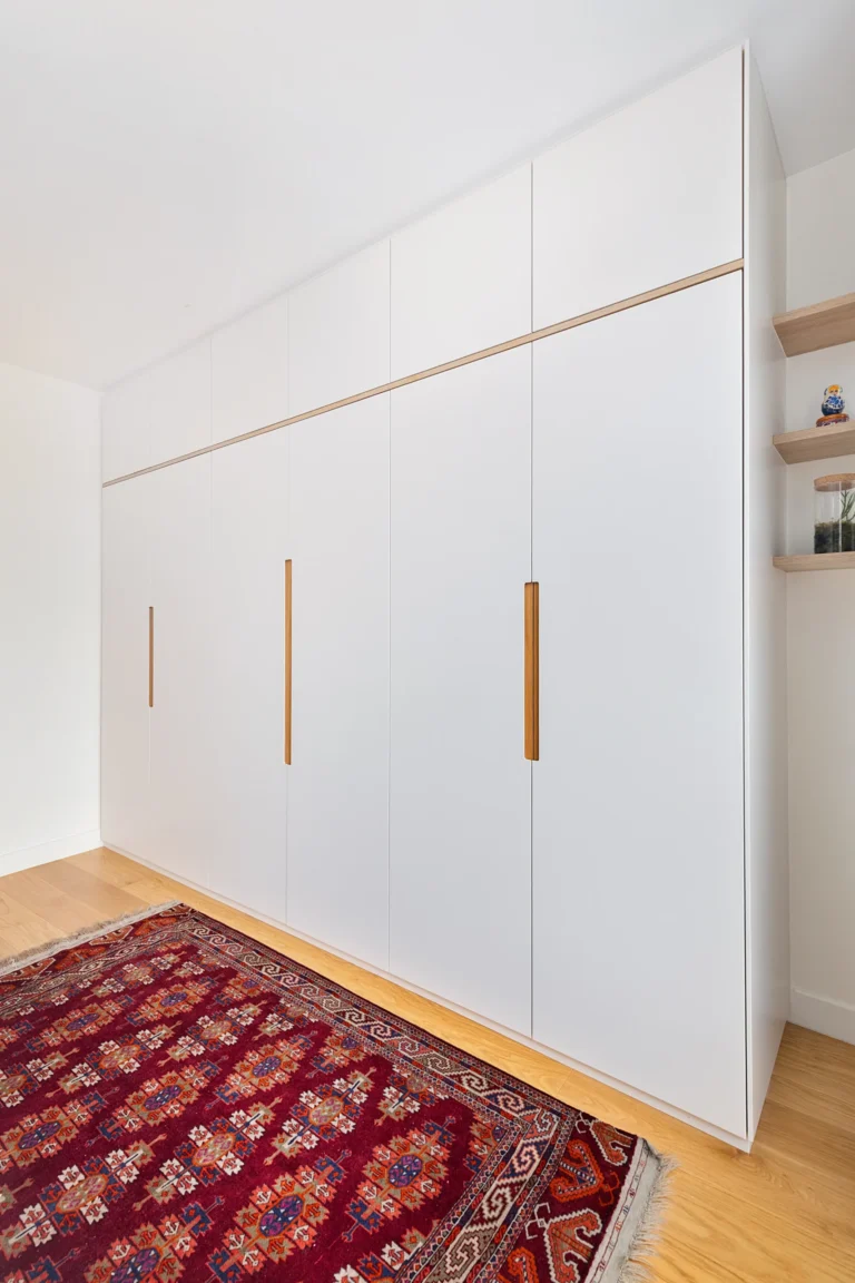 Agencement dressing sur mesure dans une suite parentale avec façades laquées blanc mat et détails en chêne clair