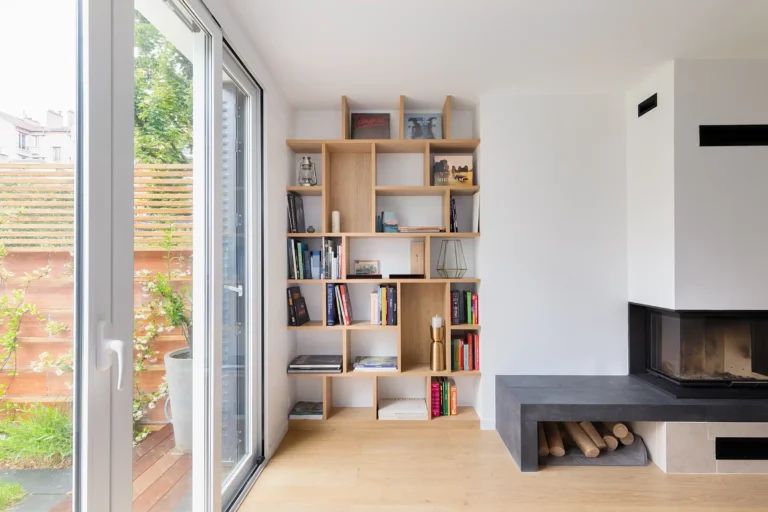 Bibliothèque en chêne clair sur mesure, intégrée entre baie vitrée et cheminée à Asnières-sur-Seine