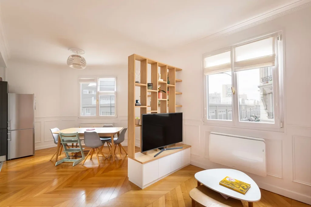 Bibliothèque claustra en bois clair sur mesure dans un salon haussmannien avec meuble bas intégré blanc mat