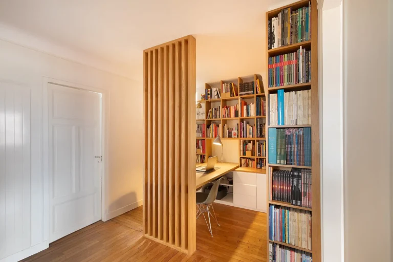 Claustra en bois et laque blanche délimitant un coin bureau design dans un espace de passage