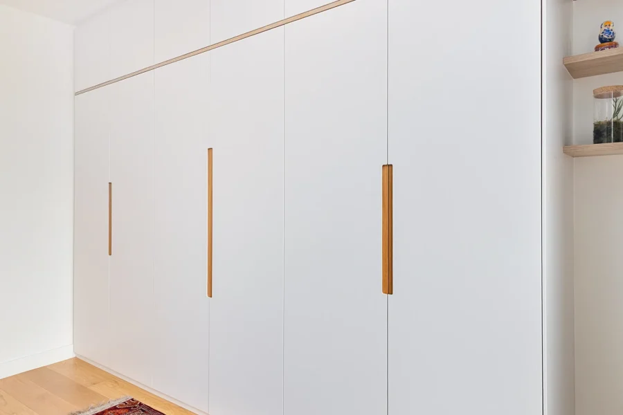 Agencement dressing sur mesure dans une suite parentale avec façades laquées blanc mat et détails en chêne clair