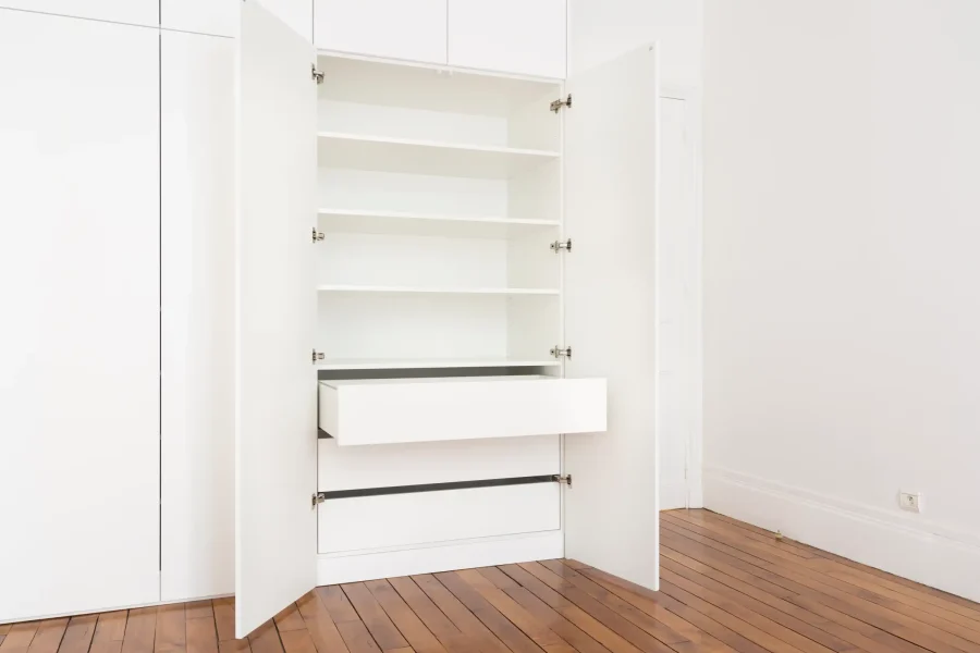 Alignement des portes de dressing blanc sur parquet ancien avec contraste visuel soigné