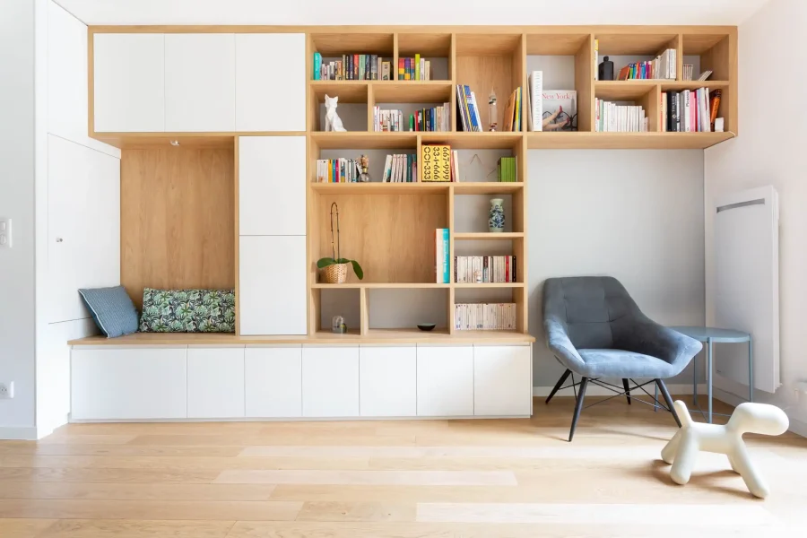 Banquette sur mesure intégrée à une bibliothèque murale en laqué blanc mat avec détails en mélaminé chêne