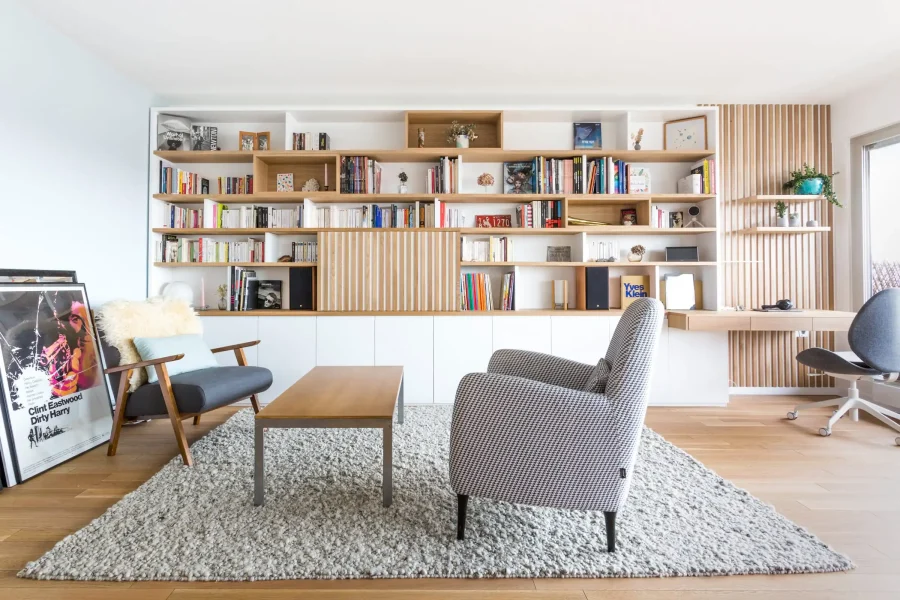 Meuble bibliothèque mural en bois clair et blanc avec niches ouvertes et rangements bas