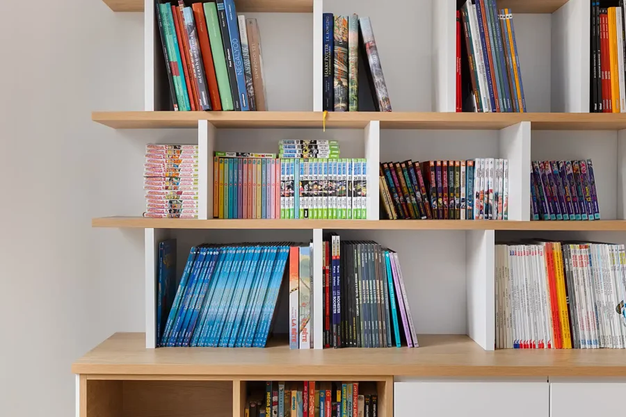 Vue d’ensemble d’une bibliothèque avec rangement bas et éléments graphiques sous verrière noire