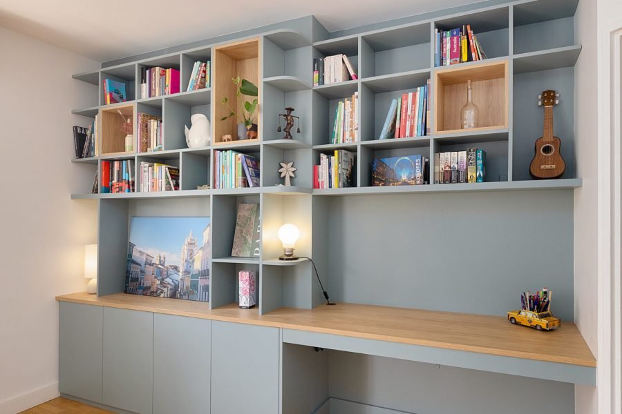 Bibliothèque sur mesure bleu gris avec bureau intégré, niches en chêne et rangements bas sans poignées