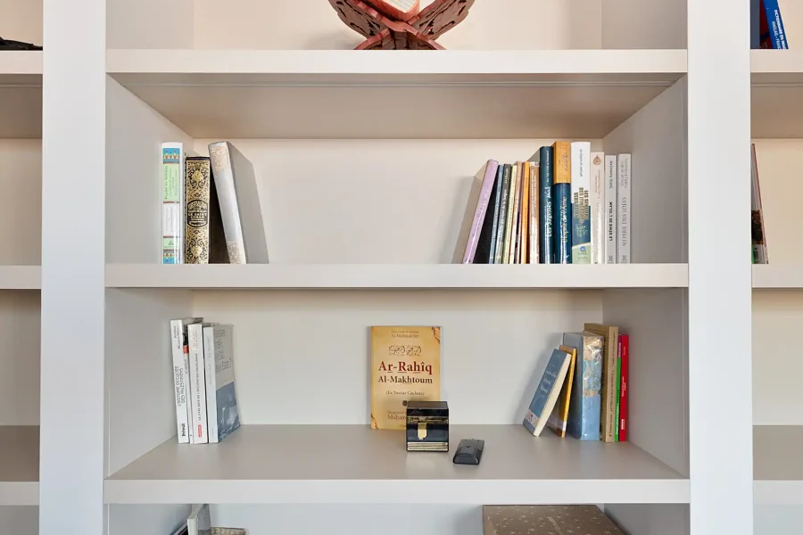 Composition symétrique avec colonnes blanches, bois clair et banquette intégrée au centre