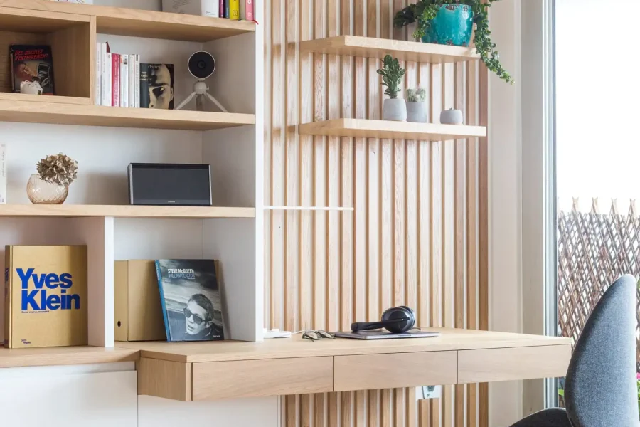 Bureau intégré dans une bibliothèque avec claustra en bois dans un salon contemporain