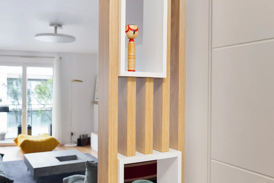 Claustra bois sur mesure dans une entrée avec tasseaux verticaux en chêne clair et niches blanches