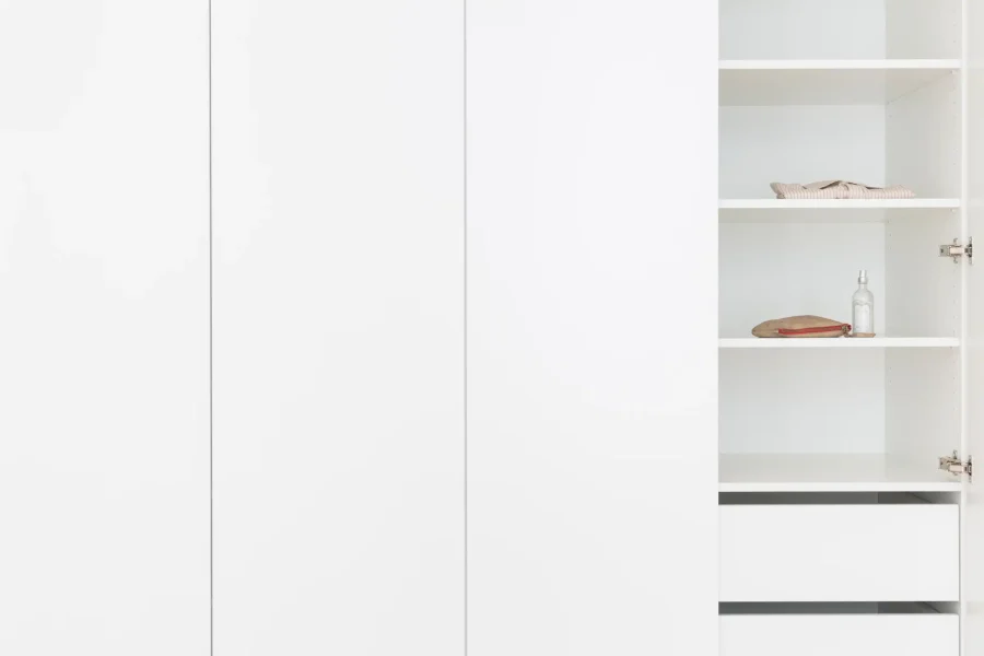 Détail d’un dressing minimaliste avec lignes épurées et finitions soignées en bois laqué blanc