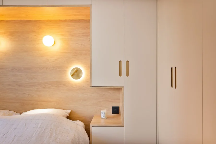 Détail tête de lit bois clair avec prises intégrées et poignées discrètes