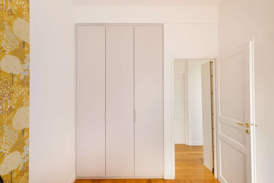 Dressing mural chambre en mélaminé blanc mat avec lignes verticales sobres et intégration murale discrète