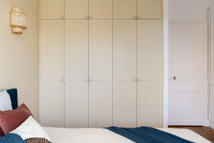 Dressing mural toute hauteur en finition bois mat écru dans une chambre parentale
