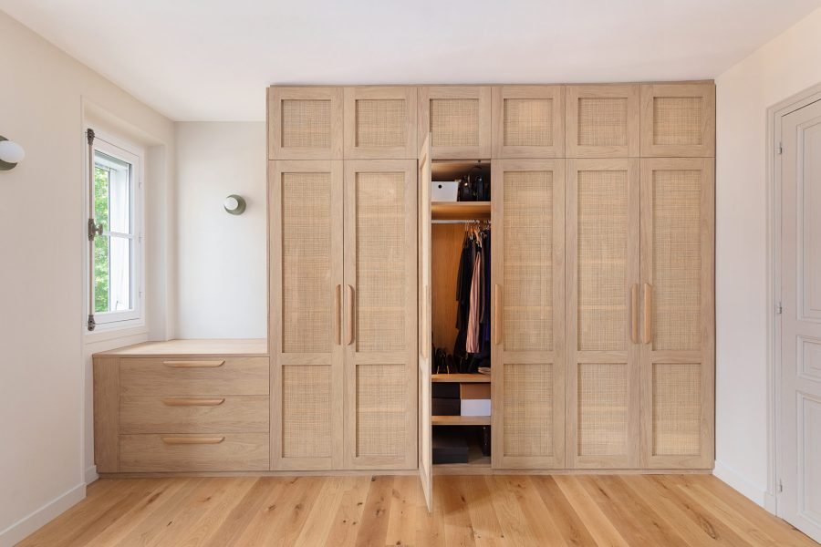 Dressing sur mesure avec portes en cannage naturel, intérieur bois et éclairage LED discret