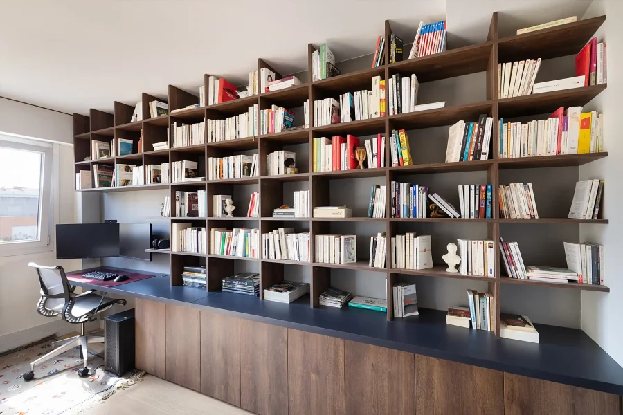 Ensemble bibliothèque et bureau intégré en bois foncé dans pièce à vivre lumineuse