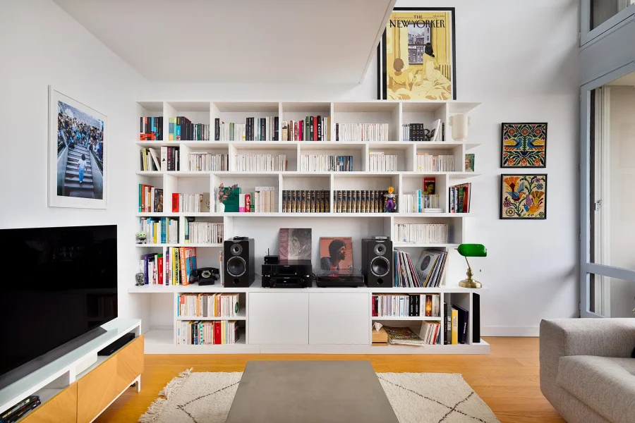 Vue d’ensemble d’une étagère murale bois blanc autour d’un espace TV et hi-fi