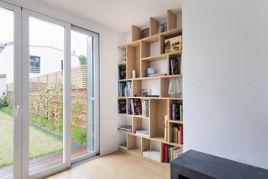 Étagère sur mesure dans un renfoncement mural, structure asymétrique en bois clair et rangement décoratif