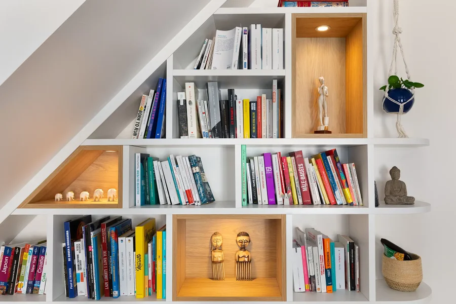 Intégration sur mesure de la bibliothèque sous l’escalier avec finitions soignées
