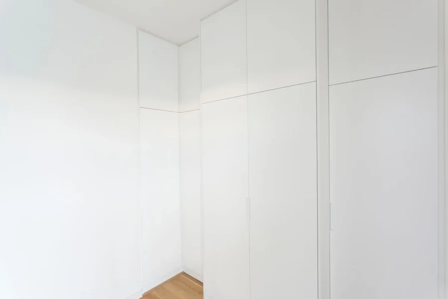 Vue latérale d’un meuble d’angle avec retour sur deux murs et finitions discrètes