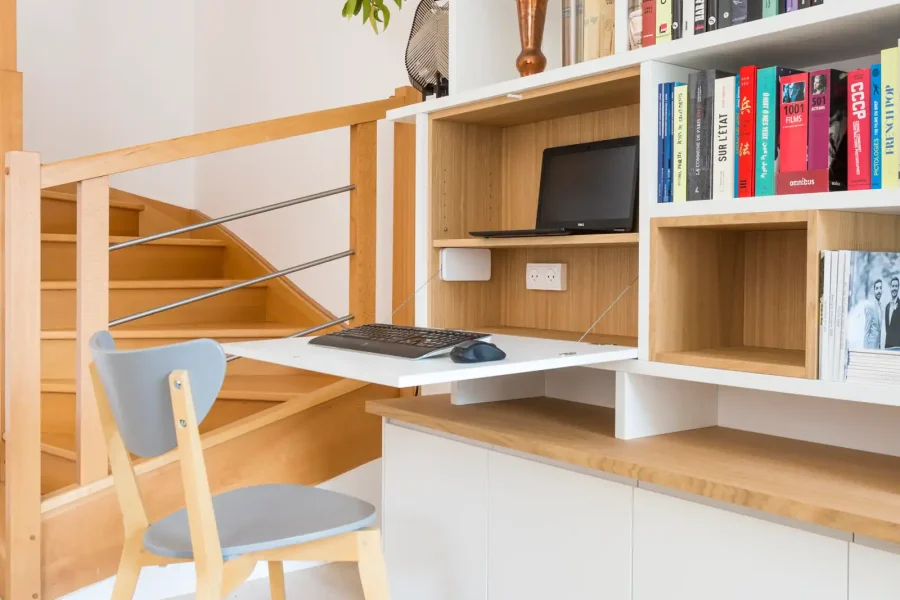 Détail du bureau escamotable intégré au meuble TV et bibliothèque