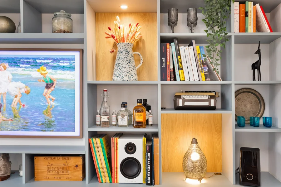 Meuble TV sur mesure adapté à un plafond incliné avec niches en bois clair