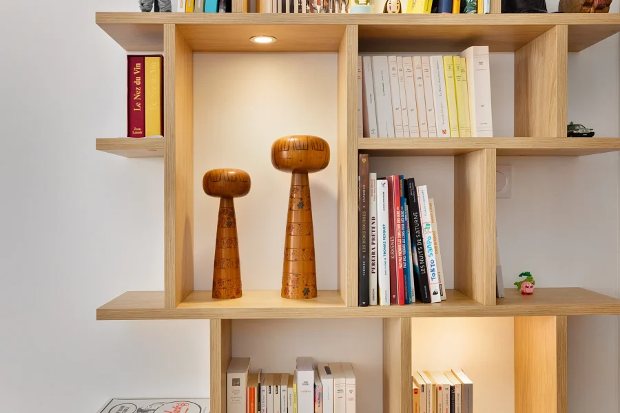 Module bibliothèque en mélaminé décor chêne clair aligné avec un meuble bas blanc