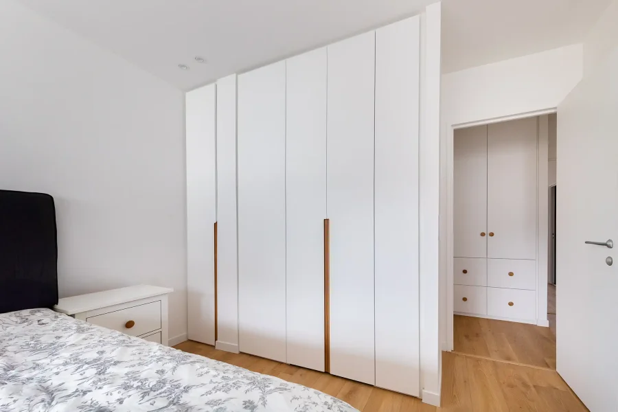 Détail des poignées intégrées en bois massif sur façades laquées blanches