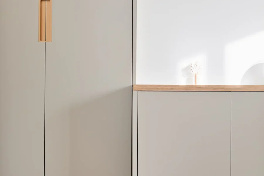 Détail des poignées en laiton et finitions bicolores du dressing