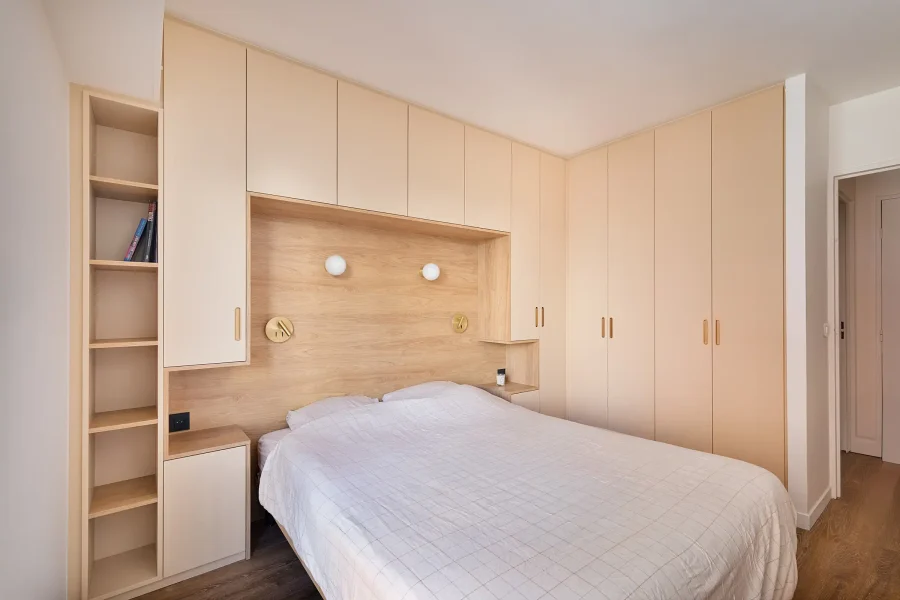 Tête de lit en niche encastrée avec rangements toute hauteur en mélaminé bois clair et façades unies